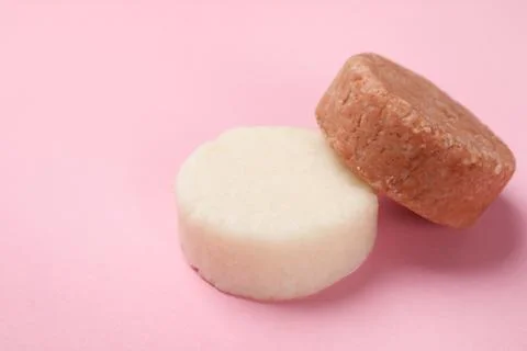 Solid shampoo bars on pink background, closeup. Space for text 写真素材