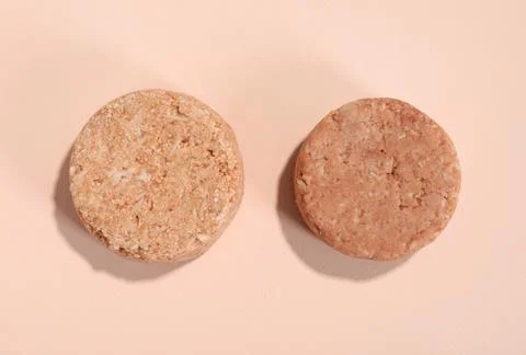 Solid shampoo bars on pink background, flat lay. Hair care 写真素材