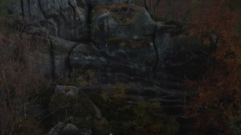 Solid, stone wall of the canyon. A wall of solid rock on which you can see green Stock Footage 125755659