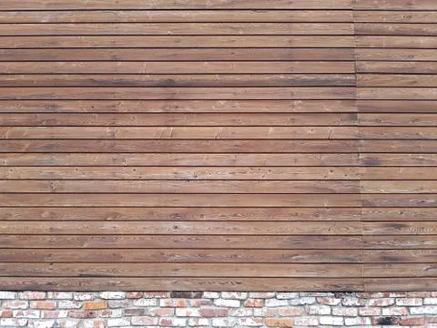 A solid wall of aged brown wooden planks with hammered nails located horizont Stock Photos