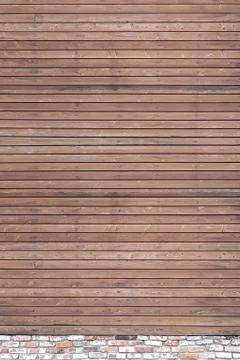 A solid wall of aged brown wooden planks with hammered nails located horizont Stock Photos