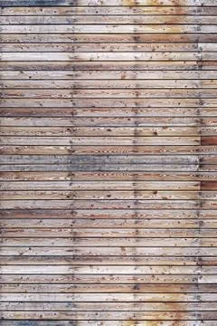 A solid wall of aged brown wooden planks with hammered nails located horizont Stock Photos