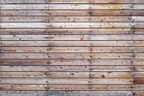 A solid wall of aged brown wooden planks with hammered nails located horizont Stock Photos