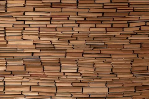Solid Wall of Stacked Vintage Books Creating a Textured Paper Background Stock Photos