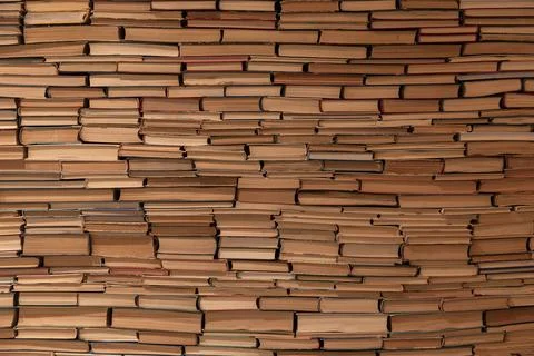 Solid Wall of Stacked Vintage Books Creating a Textured Paper Background Stock Photos