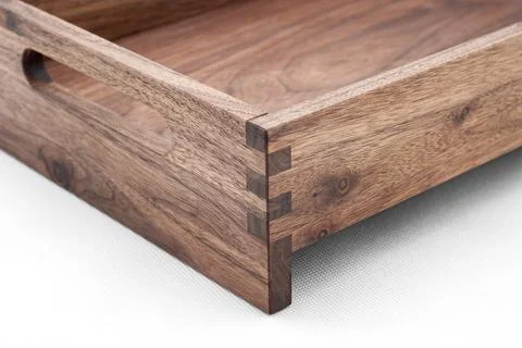Solid walnut wood tray with dovetail joints and cutout handles closeup Stock Photos
