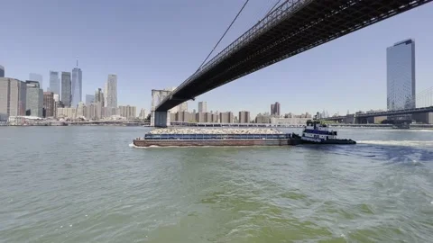 Solid waste management by barge and tugboat in New York, Brooklyn Bridge; Stock Footage 199246491