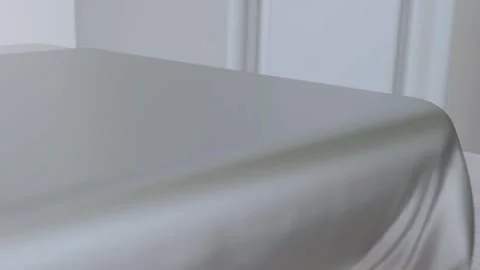 Solid White Silk Draping onto White Marble Table Video Stock Footage 337636902