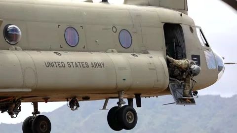 Solider looking out from front door of CH-47 Chinook while hovering Stock Footage 161243608