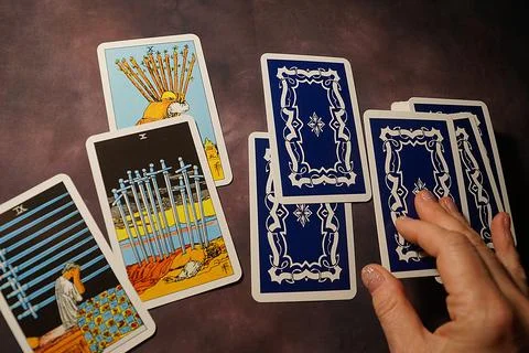 Solitaire layout, female hands spread tarot cards on the table Stock Photos
