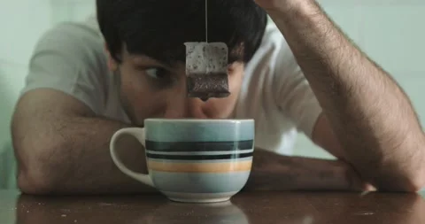 Solitude, depression - depressed man in the kitchen stares at the tea bag Stock Footage 197743728