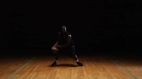 A solo basketball player does some dribbling moves in front of the camera Stock Footage 33834799