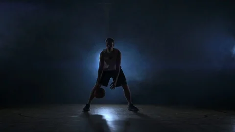 A solo basketball player does some dribbling moves in front of the camera Stock Footage 100424163