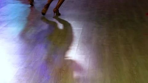 Solo dancer dances a Latin American program on a floodlit parquet floor at a Stock Footage 323873423