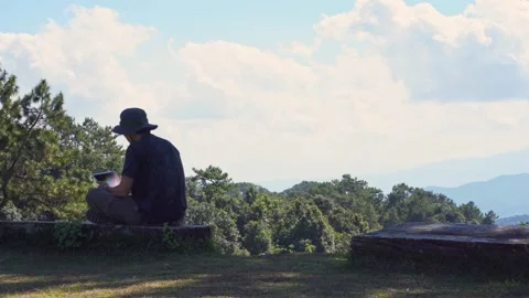 Solo freelancer man use tablet work from outdoor with layer of mountain Stock Footage 262608172