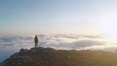 Solo girl walks on mountain top above clouds Stock Footage 168564243