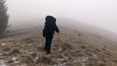Solo Hiker with Large Backpack Walking through Heavy Mountain Fog Stockbeeldmateriaal 335098968