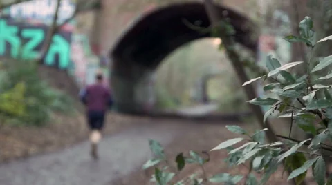 Solo Jogger runs under train bridge Stock Footage 45287831