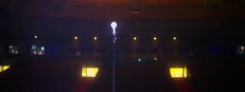 Solo microphone on stage in front of empty concert hall, gimbal anamorphic shot Stock Footage 250006714