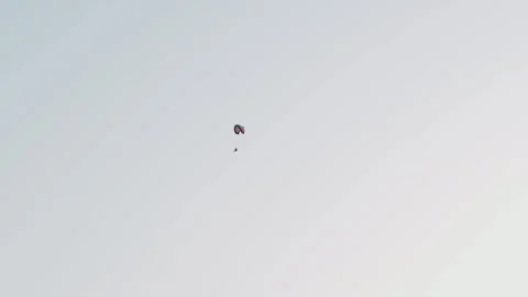 Solo paramotor pilot drifting through vast pale sky minimal composition high Vídeo Stock 332218298