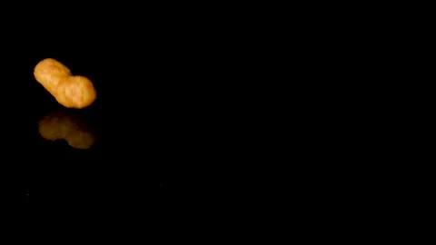 Solo peanut flip falling on black reflective background in slow motion. Stock Footage 151883952