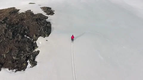 Solo skier in red jacket crossing pristine snow on mountain slope - Ski Touring Stock Footage 340524055