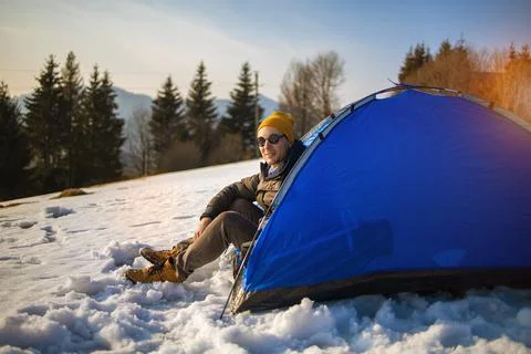 Solo young man traveller camping through an evergreen winter forest in Canada Stock Photos