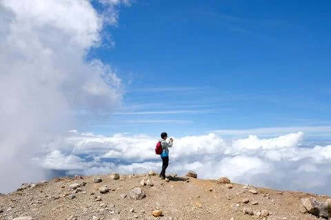 Solok Regency, Indonesia - August 2, 2025: Hiker capturing a scenic view Stock Photos