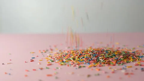 Сolorful sprinkles falling on pink background, decoration for cake and bakery Видео 138792604