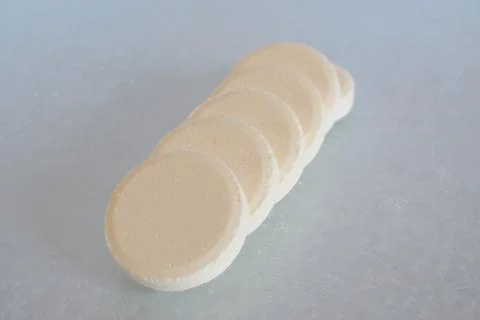 Soluble tablets in a row on glass table top closeup Stock Photos