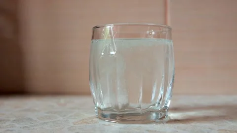 Soluble vitamin c tablet or headache tablets falls into a glass of water Stock Footage 202647110