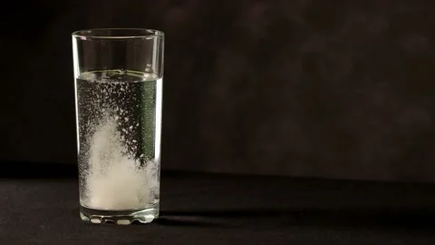 Soluble white pill and is dissolving in a glass of water Stock Footage 151037768