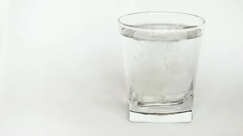 Soluble white tablet dissolves in glass of water Stock Footage 19021775