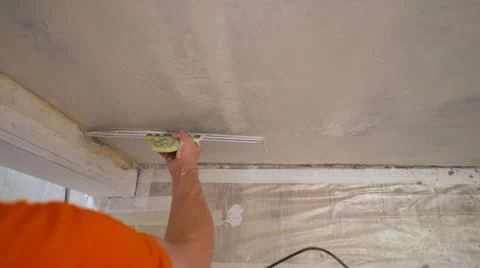 The solution is applied with a spatula to the wall. Hand with a spatula, work Stock Photos