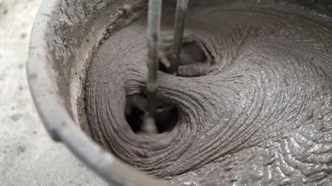 The solution in the bucket is mixed using a construction mixer. Mixing plaste Stock Photos