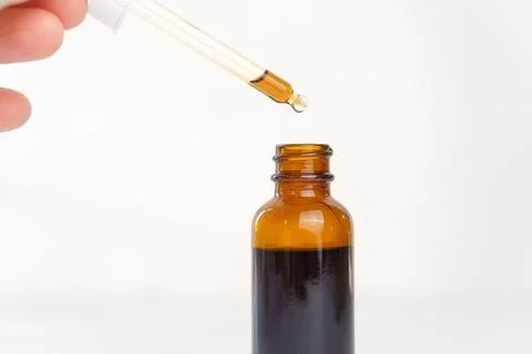 The solution is dropped from the pipette into the bottle. Stock Photos