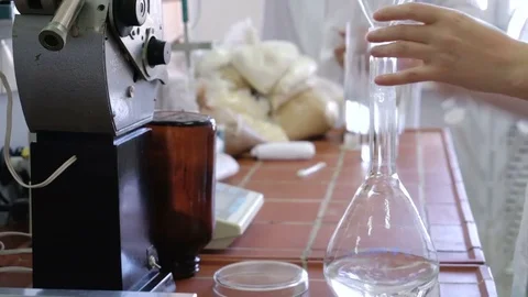 The solution is poured into the flask. Laboratory equipment. The lab assistant Video stock 74208287