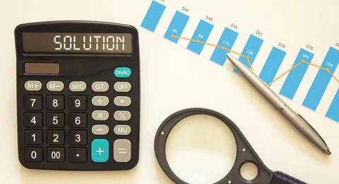 SOLUTION text on calculator, near charts, magnifier and pen on white backgrou Foto stock