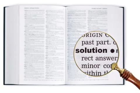 Solution through a magnifying glass over dictionary. Stock Photos