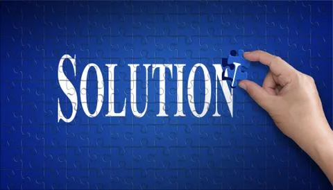 Solution word on Jigsaw puzzle. Man hand holding a blue puzzle to complete th Stock Photos