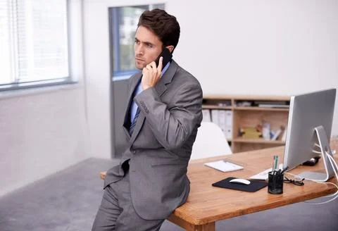 Solving business problems via cellphone. A young businessman busy on an 写真素材