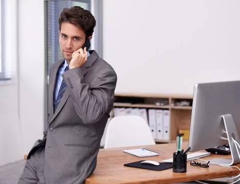 Solving business problems via cellphone. A young businessman busy on an Stock Photos