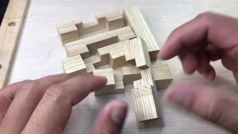 Solving a complex interlocking wooden cube puzzle by hands Stock Footage 317598743