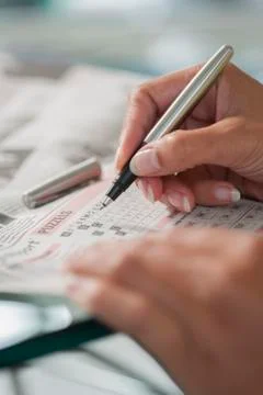 Solving a crossword puzzle close-up Stock Photos