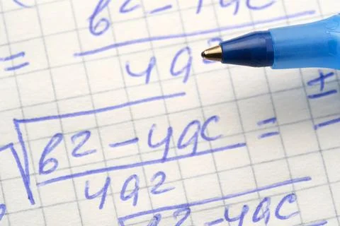 Solving math problems with blue pen on graph paper 스톡 사진