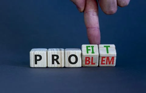 Solving a problem and making profit symbol. Businessman turns wooden cubes, c Stock Photos