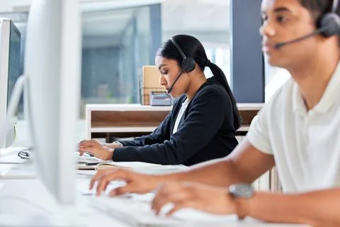 Solving problems one at a time. two young businesspeople sitting in the office Stock Photos