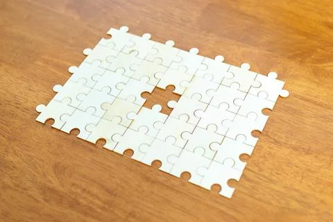 Solving the puzzle challenge empty space in a jigsaw home setting close-up .. Stock Photos