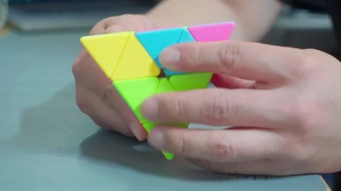 Solving Pyraminx Puzzle Toy Close Up 4K Video stock 339124174