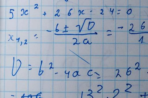 Solving quadratic equations in a notebook during a study session Stock Photos